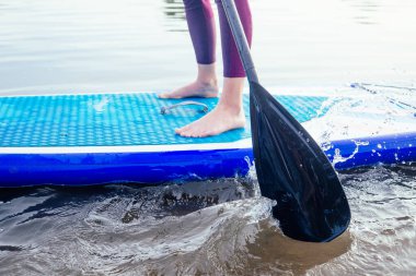 Durgun bir göl kıyısında ayakta durun, bacaklarınızı yakın tutun ve su sıçratın.