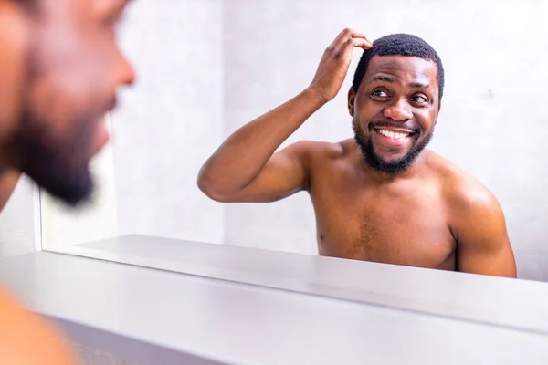 good-looking brazilian man smiling morning cheer up himself looking at mirror in bathroom