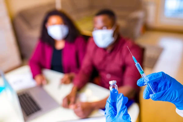 Afro-Amerikan erkek ve kadın tıbbi maske takıyor ve Coronavirus aşısı yaptırıyor.