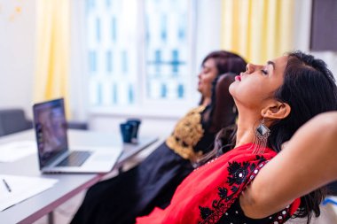 İki Hintli üniversite ofiste tablet bilgisayar kullanarak fikirleri tartışıyor.