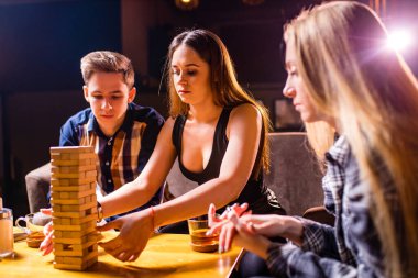 Gençler masa başında oyun oynarken eğleniyorlar.