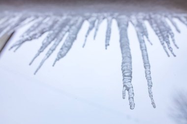 Rusya 'nın kış günü çatıda sallanan buz sarkıtları