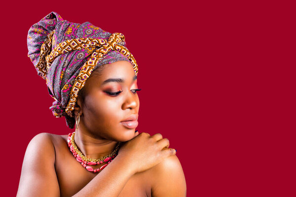 подлинный смешанной расы boho моды леди с макияжем и шелковый тюрбан над головой в красном фоне студии