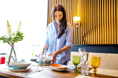 Çinli tasarımcı görgü öğretmeni bir restoranda tabakları ne kadar doğru yerleştirdiğini gösteriyor.