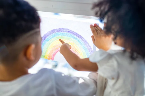 Zwei brasilianische ethnische Kinder mit Regenbogen bemalt mit bunten Fensterfarben zu Hause bleiben drinnen — Stockfoto