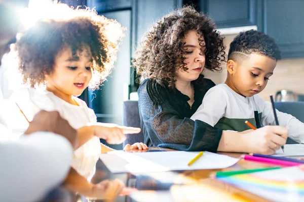 cute curly afro hair girl and boy drawing with her mothers parents positive education tolerance amazing day light sun on curls hair