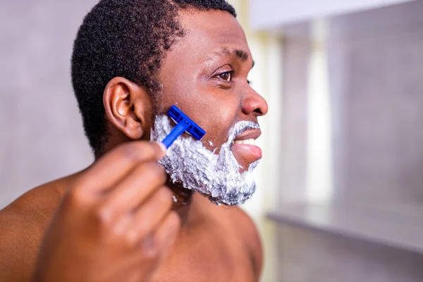Homme hispanique mettre de la mousse sur la lotion de parfum de barbe ou crème de soin de la peau pour les peaux sensibles — Photo