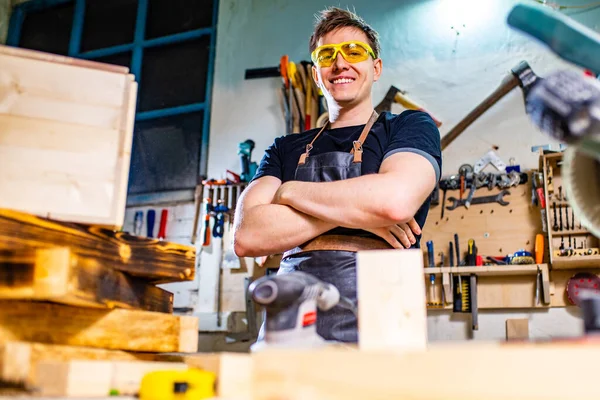 Carpintero joven trabajando con madera en taller —  Fotos de Stock