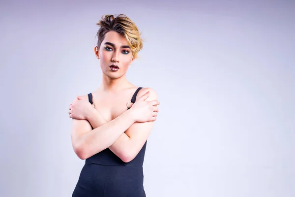 Beyaz arka planı rujlu genç bir adamın yakın plan portresi.