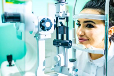 Optometrist laboratuarındaki Arap hasta görme ve görme düzeltmelerini kontrol ediyor.