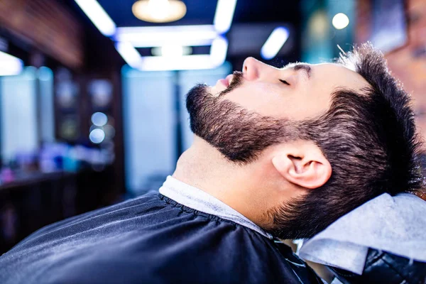 Hispânico barbudo homem ter seu cabelo cortado por cabeleireiro na barbearia — Fotografia de Stock