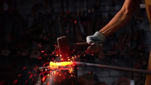 Slow motion close-up hand met de hamer van smid man smeert een metalen product in het donker binnenshuis studio — Stockvideo