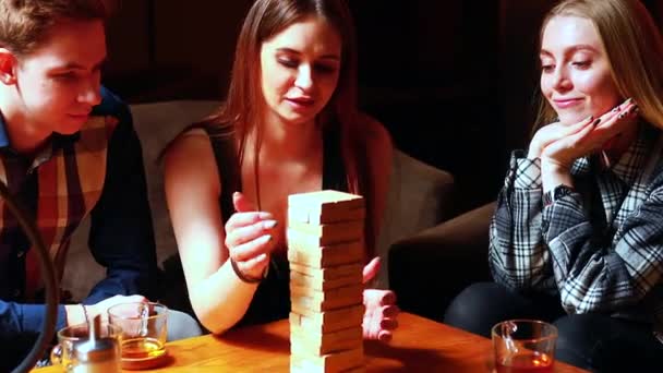 Des gens authentiques Les jeunes s'amusent à jouer à des jeux de société à une table dans un café — Video