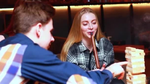 Los jóvenes se divierten jugando juegos de mesa en una mesa en la cafetería — Vídeos de Stock