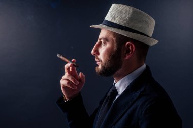 Siyah arka planda purosu olan çekici bir iş adamının portresi.