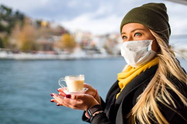 Önde Masala çayı içen kadın, arkada Bosphorus Körfezi.
