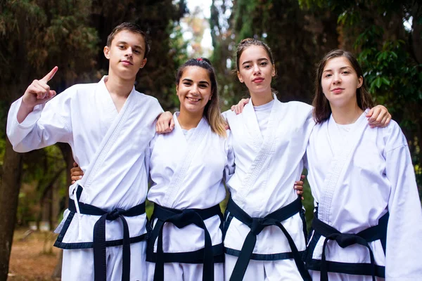 Pessoas chutes altos durante o treinamento de taekwondo ao ar livre fundo de bambu — Fotografia de Stock