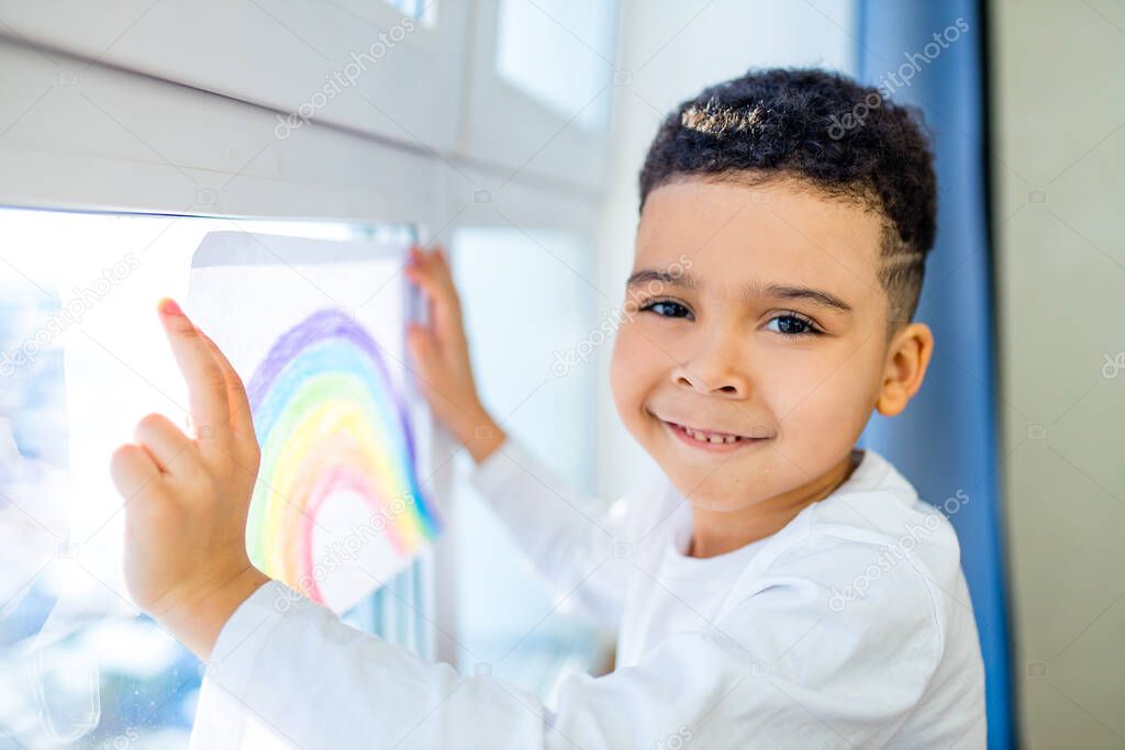 brazilian ethnic kids with rainbow painted with colorful window color staying at house indoor