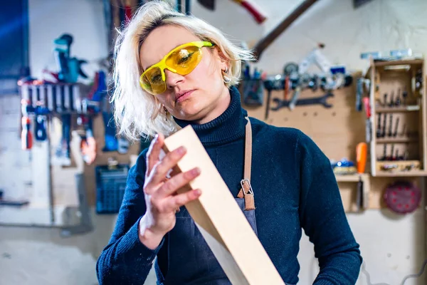 Blondýnka žena tesař pomocí nástrojů pro její práci v obchodě se dřevem — Stock fotografie