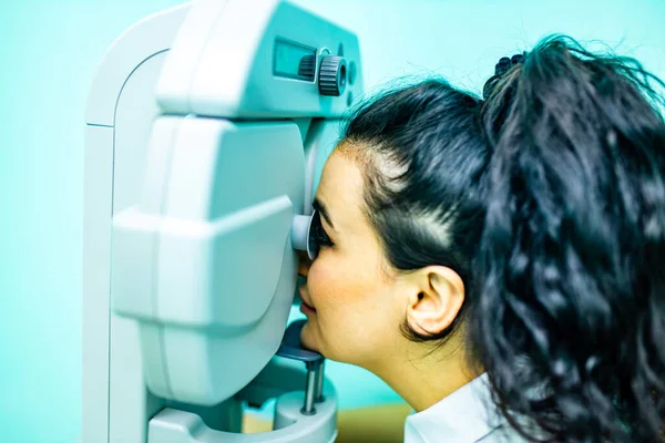 arabian patient checking eyesight and vision correction in optometrist lab