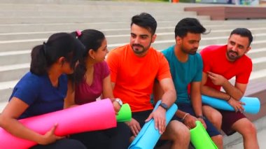 Spor salonunda konuşan dört Hintli sabah vakti şehir kıyafetlerini giyer.