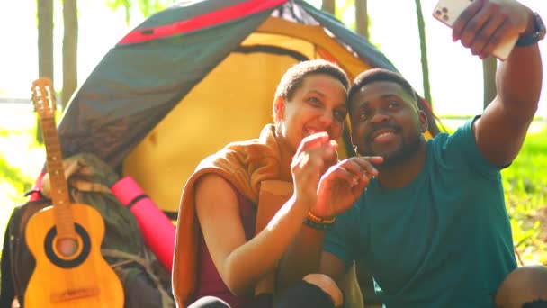 Çadırda modern akıllı telefon kullanarak selfie çeken Afro Latin bir çift. — Stok video