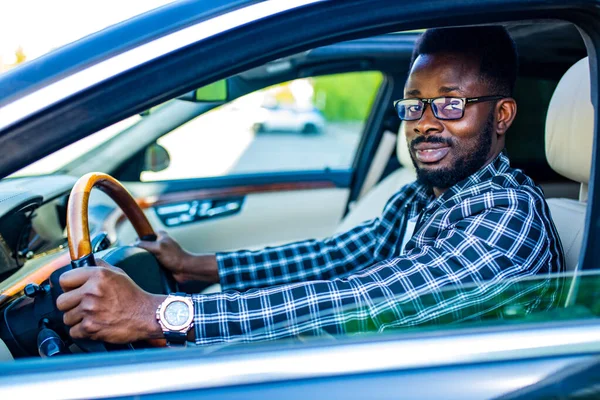 Handsome bearded man sitting relaxed in his newly bought car outdoors