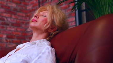 Gri saçlı, huzurlu, güzel bir kadın. Rahat bir kanepede uyuyor. Temiz hava soluyor, gözleri kapalı meditasyon yapıyor.