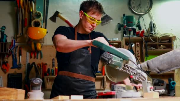 Genç marangoz testere testeresiyle tahta kesiyor. — Stok video