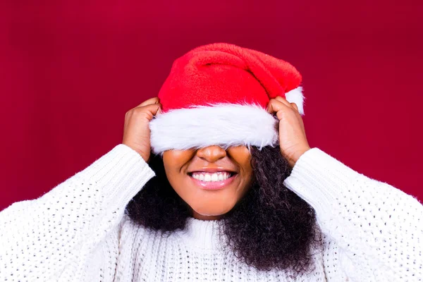 Glad söt kvinna i röd jultomte hatt skrattar isolerad på röd bakgrund hon är glad och upphetsad full av kul — Stockfoto