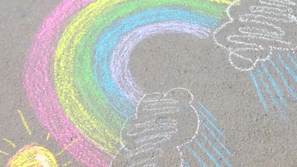 Teenage girl drawing a rainbow colored chalk on the asphalt on summer day — Stock Video