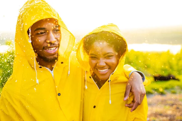アフリカ系アメリカ人の妻と夫が黄色のレインコートに身を包み — ストック写真
