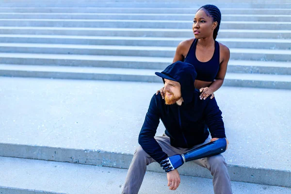 Sorrindo jovem mestiço casal em sportswear aquecimento ao ar livre sity fundo manhã cedo — Fotografia de Stock