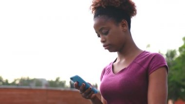 Parkta kablosuz internet kullanan üzgün kadın pembe kıyafetler giyiyor.