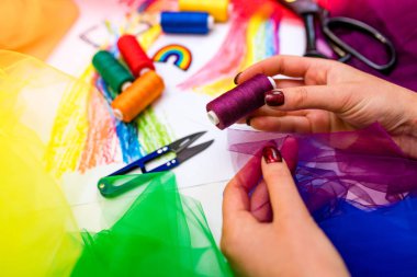 Çok renkli kumaş parçaları ve masanın üzerinde bir iplik. Geçit töreni için hazırlık.