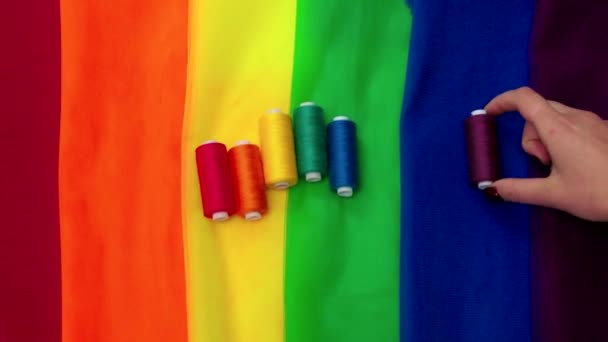 Piezas multicolores de tela y un hilo en la preparación de la mesa para el paseo desfile lgbt — Vídeo de stock