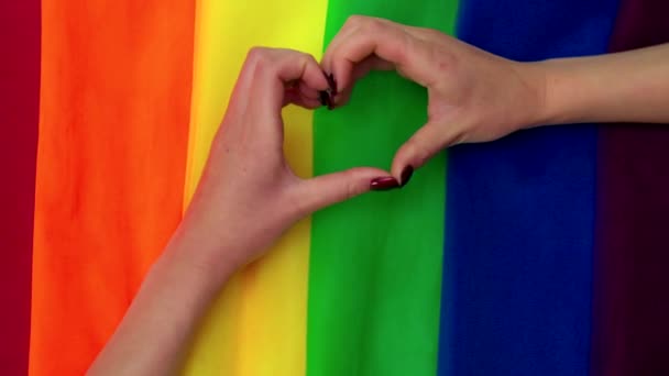 Heart hand of female on the multi color flag rainbow background — Stock Video
