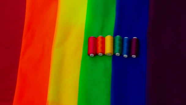 Pezzi multicolori di tessuto e un filo sulla tavola preparazione per la sfilata corsa lgbt — Video Stock