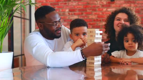 Афроамериканська сім'я змішаної раси за столом грає в настільну гру — стокове відео