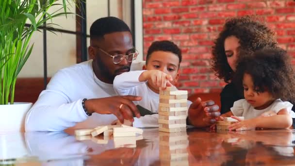 Familia africana de raza mixta palying una ronda de jenga en acogedora sala de estar con aire acondicionado — Vídeos de Stock