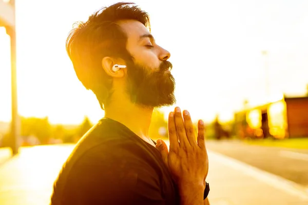 Bearded man in black cotton t-shirt warming up outdoor in summer park at sunset gold light — Stock Photo, Image