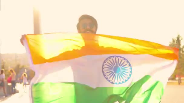 Красивий індійський бородатий чоловік у чорній бавовняній футболці, що веде індійський прапор у літньому парку на заході сонця золоте світло . — стокове відео