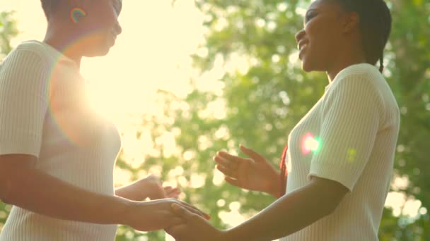 Två afro amerikanska kvinnor firar äktenskap i wtite klänning med ljusa manliga upp i sommar park . — Stockvideo