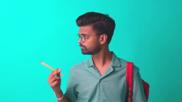 Indio estudiante hombre sensación inspiración idea usar gafas de ojo celebración de un lápiz en azul studi — Vídeo de stock