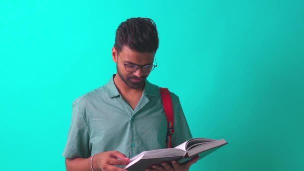 Indian student man feeling inspiration idea wear eye glasses holding a pencil in blue studi — Stock Video