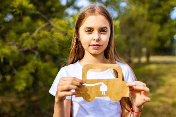 Yaratıcı zanaat hobisi olan küçük bir kız kağıt araba çevresi, çevre dostu, yaz günü parkta enerji tasarrufu. — Stok fotoğraf