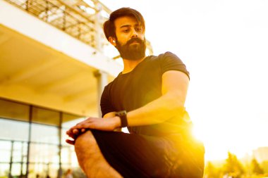 Siyah pamuklu tişörtlü Latin bir adam gün batımında dışarıda ısınan bir kulaklığı bile tanıyordu.