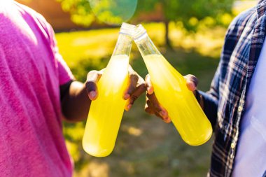 Latin Brezilyalı adam güneşli parkta sıcak yaz gününde taze soğuk limonata içiyor.