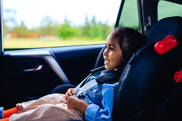 Menina de raça mista no assento do carro com cinto apertado — Fotografia de Stock