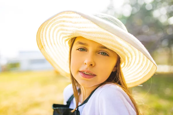 可愛いです女の子ティーンとともにブレース摩耗帽子と見ますカメラ屋外ガーデン — ストック写真